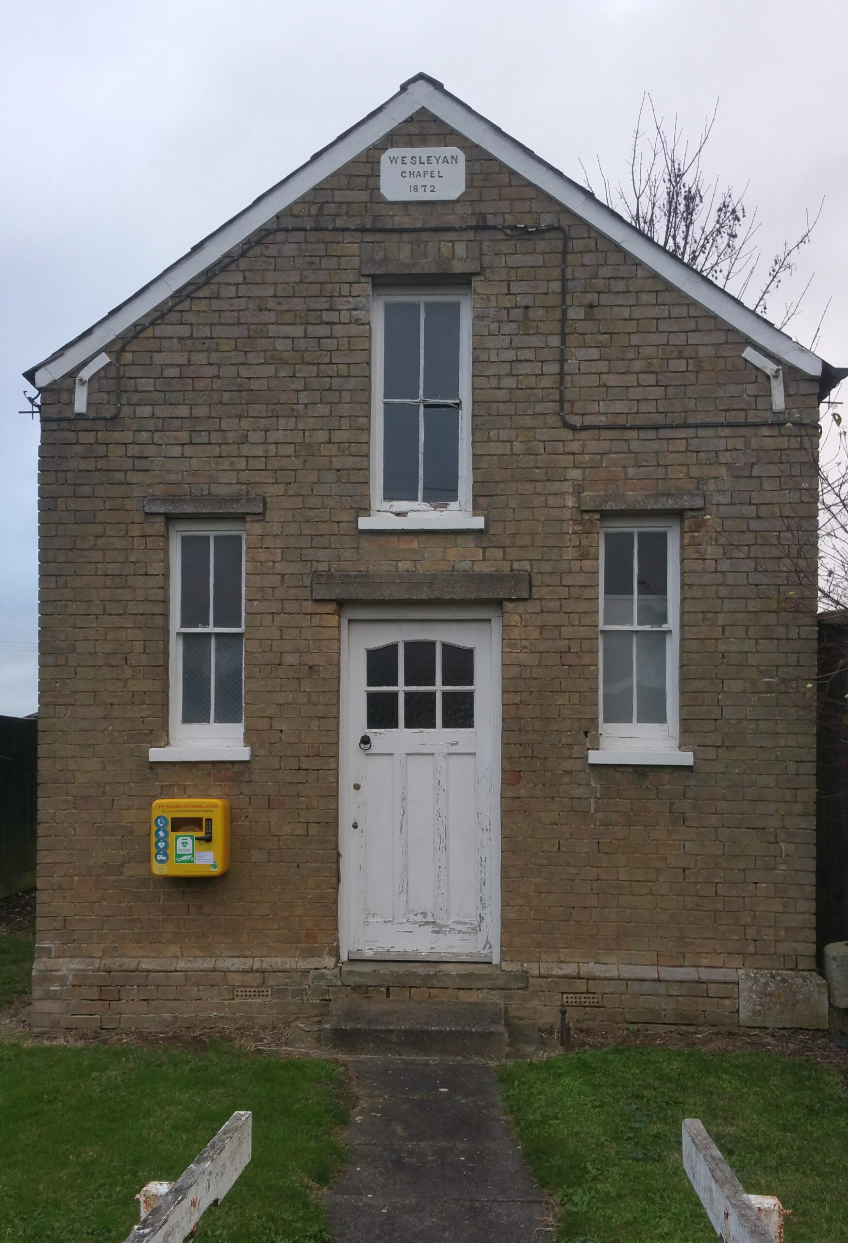 The Old Chapel in Honeydon showing the defibrillator mounted to the left of the door as you look at the chapel from the road.